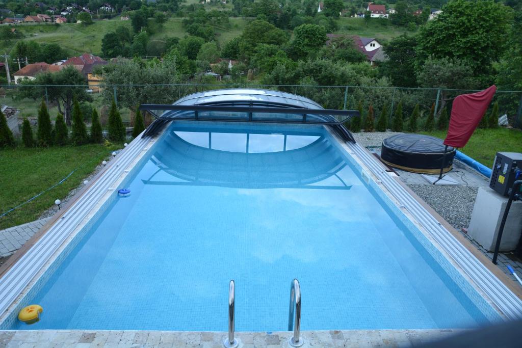 a large blue swimming pool in a backyard at Pensiunea Antonia in Bran