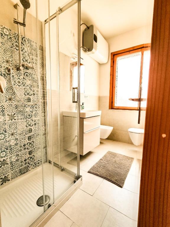łazienka z przeszkloną kabiną prysznicową i umywalką w obiekcie Appartamento Bellavista w mieście Cavo