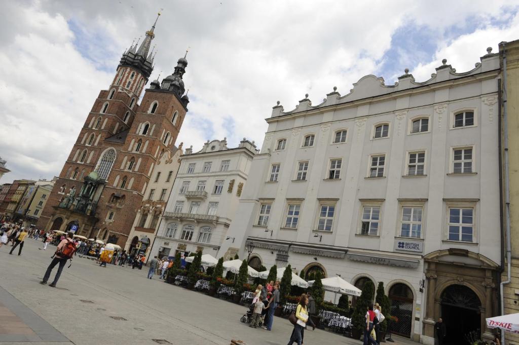 a city street with a clock tower and buildings at Apartments Rynek Glowny in Krakow