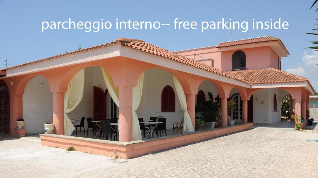 a building with a patio with tables and chairs at Bed & Breakfast Villa Corallo Parcheggio privato in Porto Cesareo