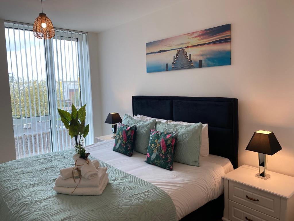 a bedroom with a bed with a large window at Berks Luxury serviced Apartments,5 Bedrooms, 5 double beds, 2 bathrooms, free super fast WiFi & parking in Earley