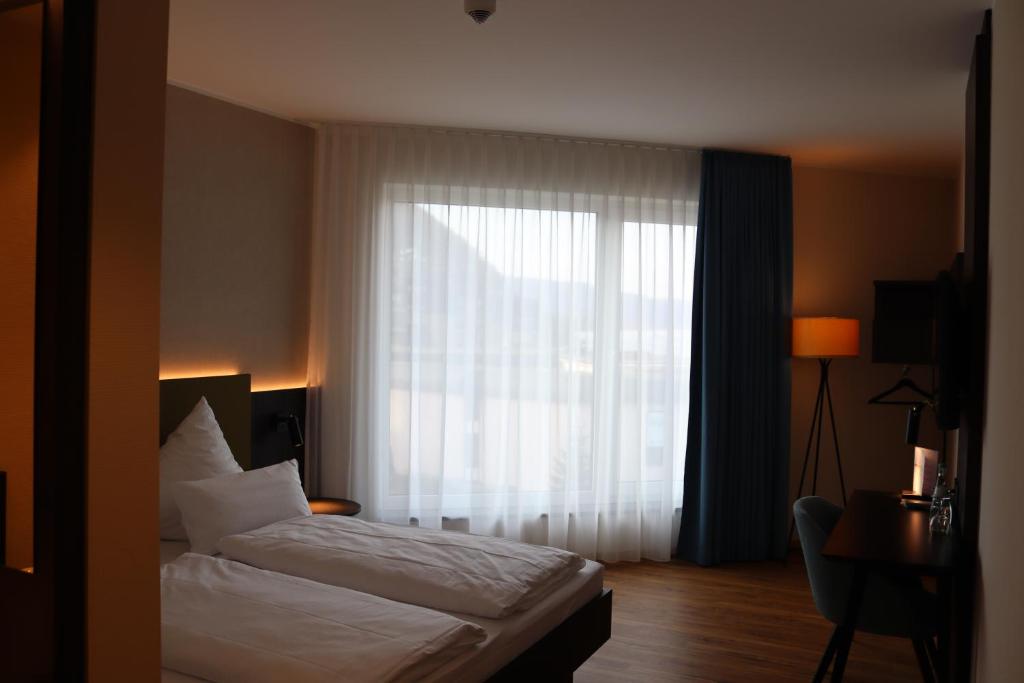 Postel nebo postele na pokoji v ubytování EINSTEIN Hotel am Römerpark