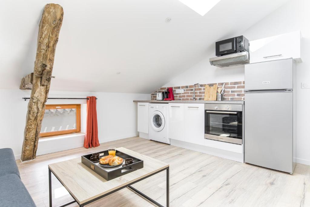 une cuisine avec des appareils blancs et une table dans une pièce dans l'établissement Gambetta401 CahorsCityStay, à Cahors