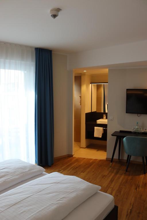 Postel nebo postele na pokoji v ubytování EINSTEIN Hotel am Römerpark