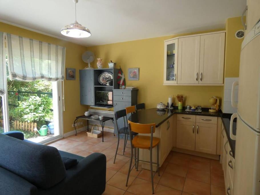 - une cuisine avec un canapé et une table dans une chambre dans l'établissement Appartement proche de la mer et du port Pays Basque Hendaye, à Hendaye
