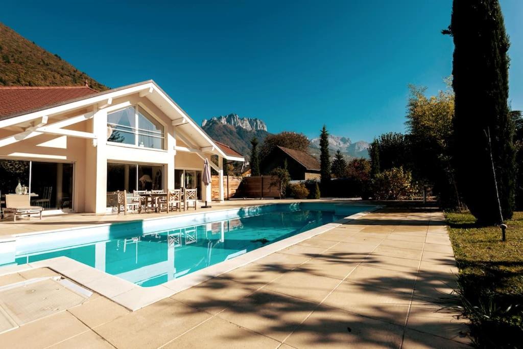 uma piscina em frente a uma casa em Studio indépendant 3 étoiles dans magnifique villa au bord du lac d'Annecy em Veyrier-du-Lac