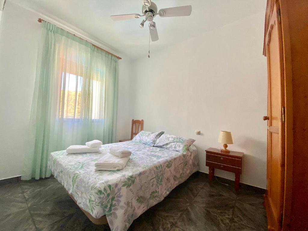 - une chambre avec un lit, un ventilateur de plafond et une fenêtre dans l'établissement Casa Antigua Estacion By Solymar Holiday, à Malaga