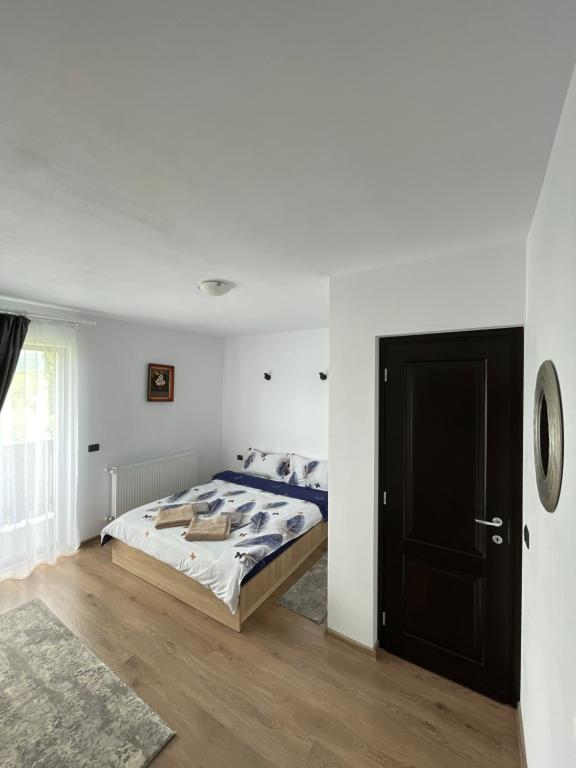 um quarto com uma cama e uma porta preta em Vila Hojda em Moisei