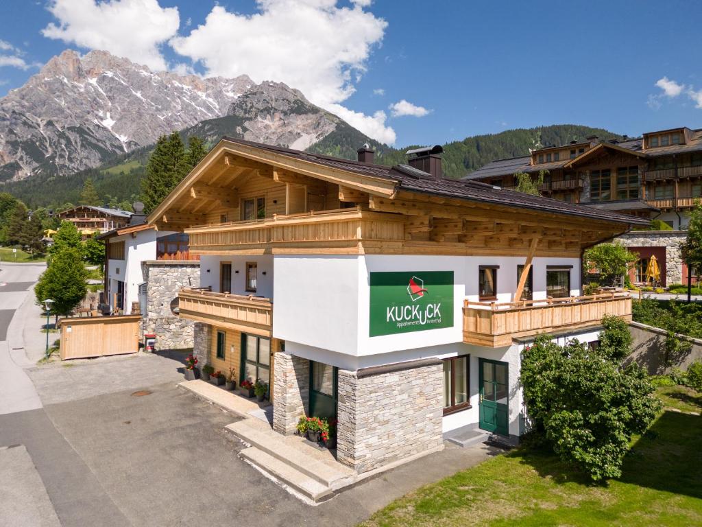 a building with a sign on it with mountains in the background at Kuckuck Hinterthal - Appartements in Hinterthal