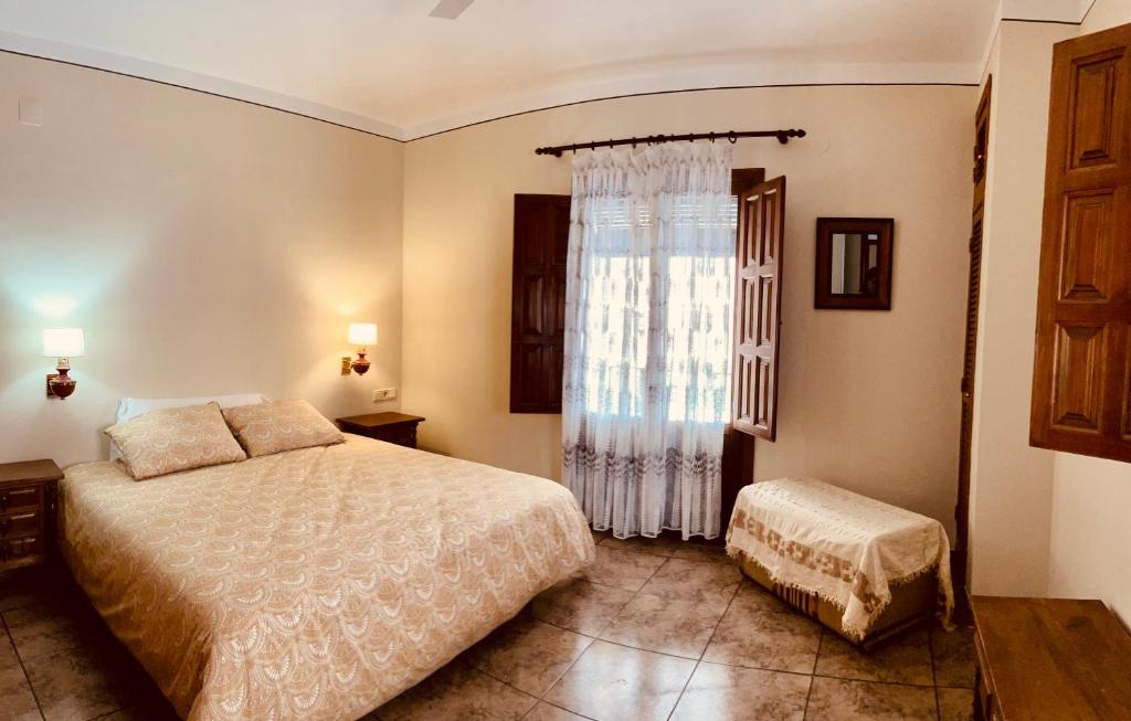 1 dormitorio con cama y ventana grande en Almahen, en Cájar