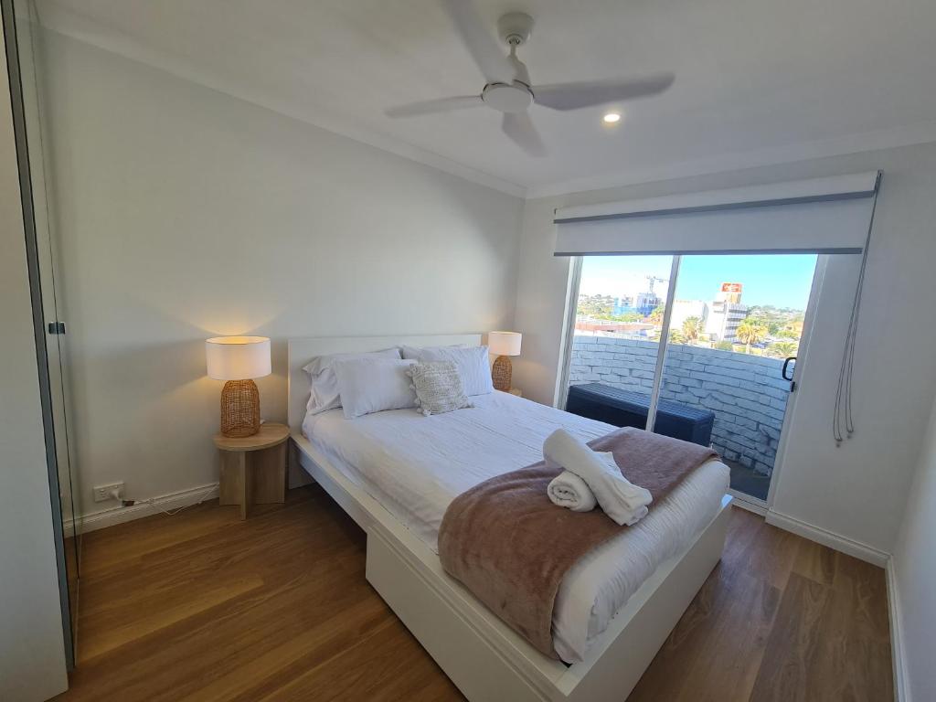 a bedroom with a bed with a large window at West Beach Lagoon 114 – Ocean Views in Perth