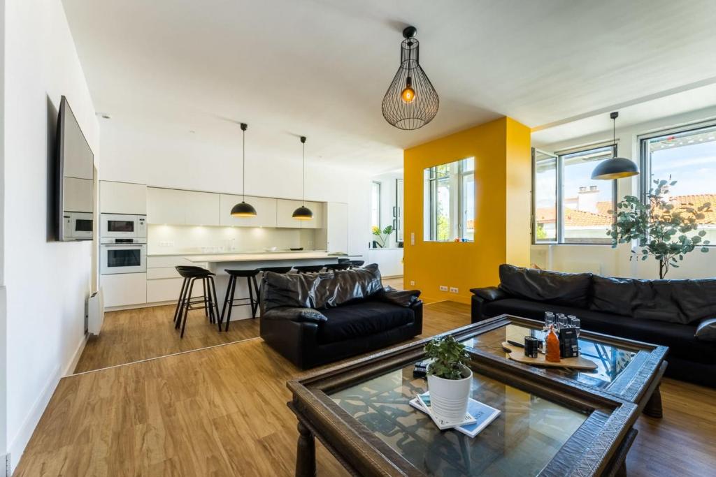 un salon avec un canapé et une table dans l'établissement MARIPOSA KEYWEEK Loft Biarritz, à Biarritz