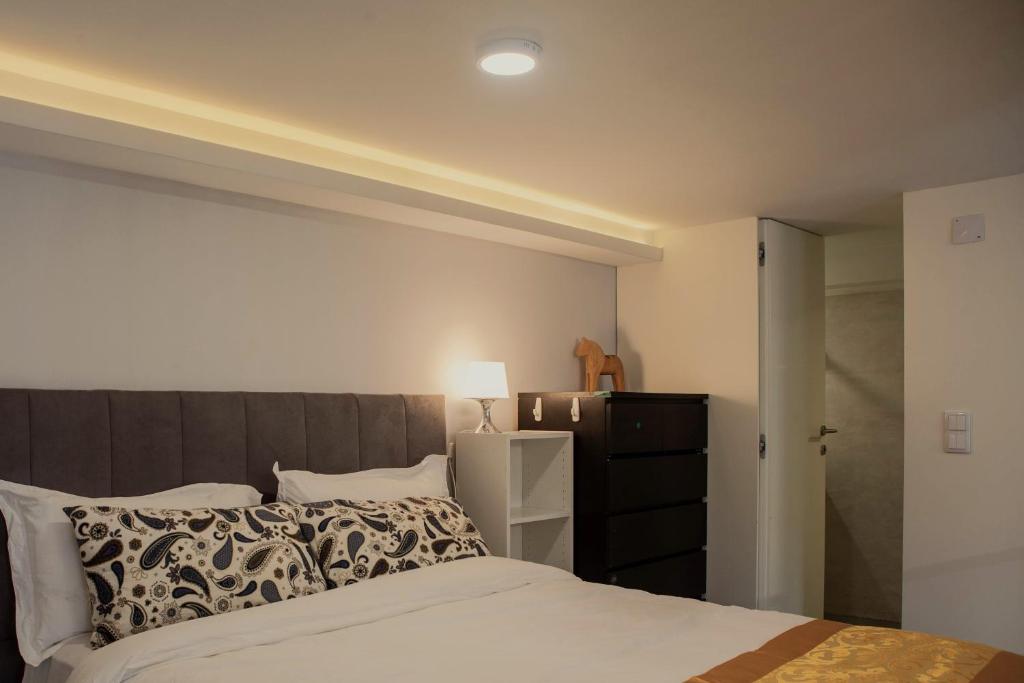 um quarto com uma cama, uma cómoda e um candeeiro em 竹林书屋 em Arneiro