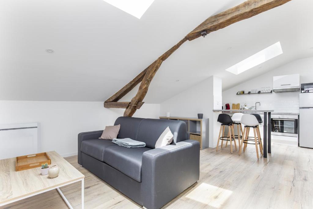 un salon avec un canapé et une cuisine dans l'établissement Gambetta402 CahorsCityStay, à Cahors