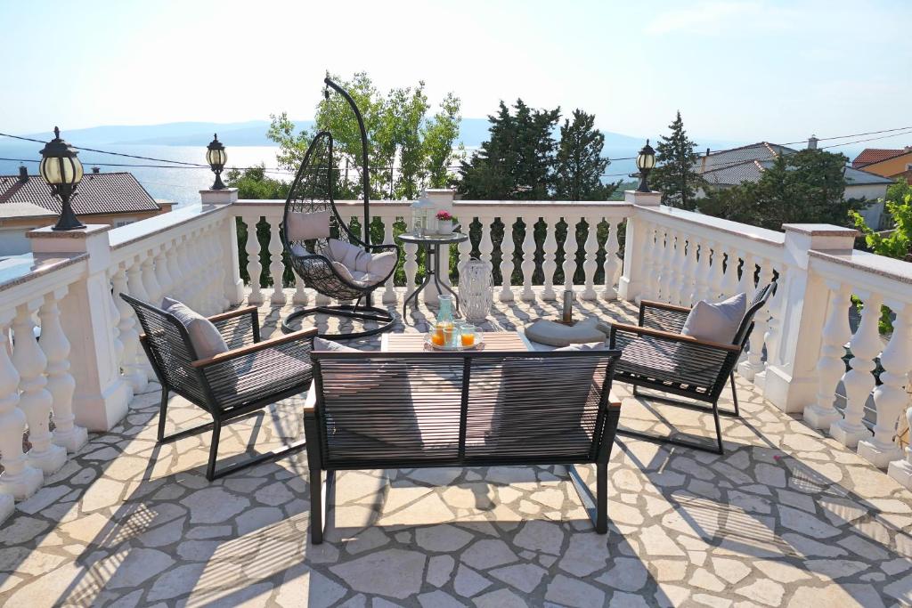 a patio with chairs and a table on a white fence at Apartment Laura in Senj