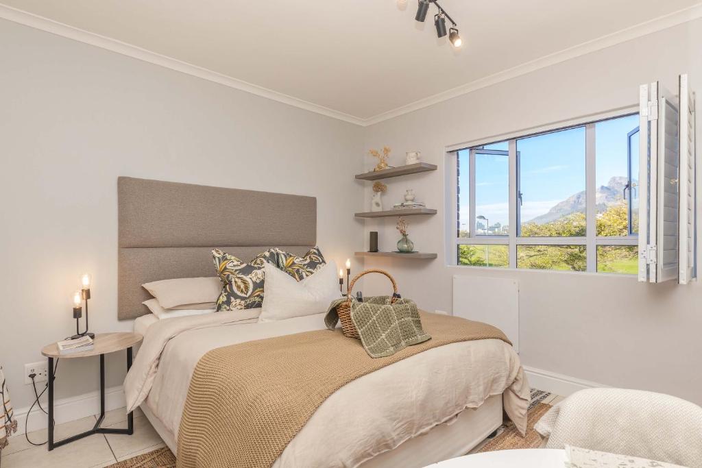 a bedroom with a bed and a window at Little Gem On The Promenade in Cape Town