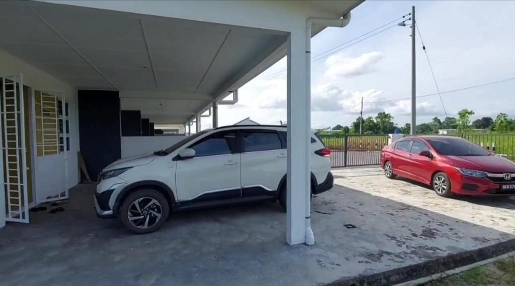 a white car is parked under a garage at 42 Avenue Homestay Samarahan in Kota Samarahan