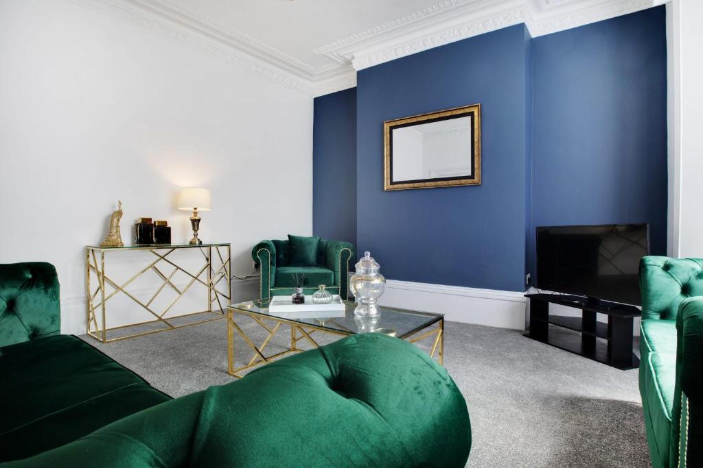 a living room with blue walls and a green couch at Stunning 4-Bedroom, 2 Bathrooms in Sunderland in Sunderland