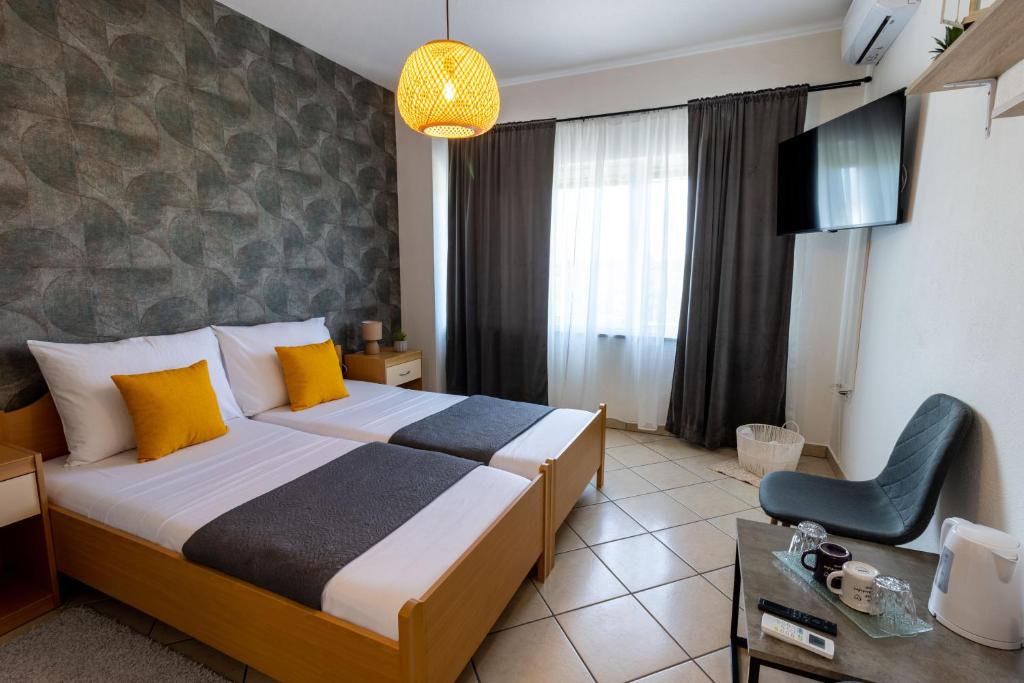 a hotel room with a bed and a chair in it at DELUXE ROOMS BURE in Murter
