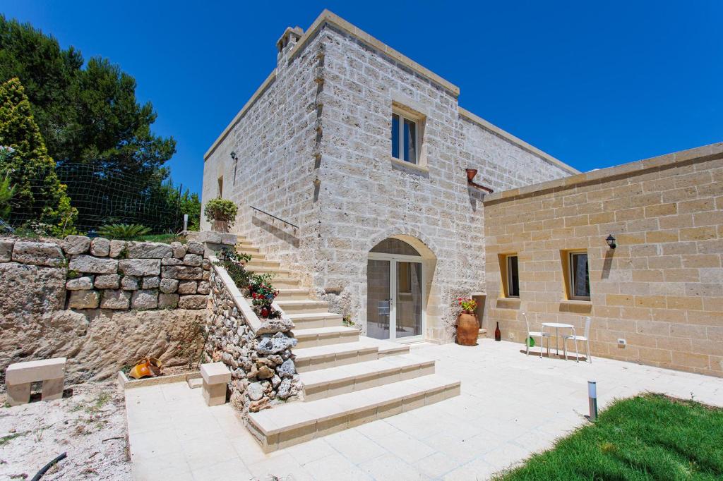 un edificio in pietra con scale accanto a un muro di pietra di Antico Casolare P. P. a Otranto