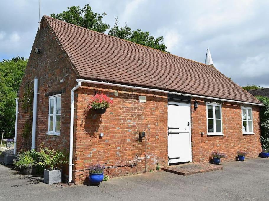 a red brick building with two white garage doors at Waters edge in Rolvenden