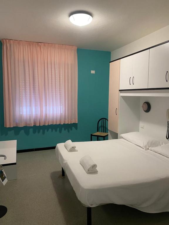 Un dormitorio con una gran cama blanca y una ventana en Hotel Gioia, en San Benedetto del Tronto