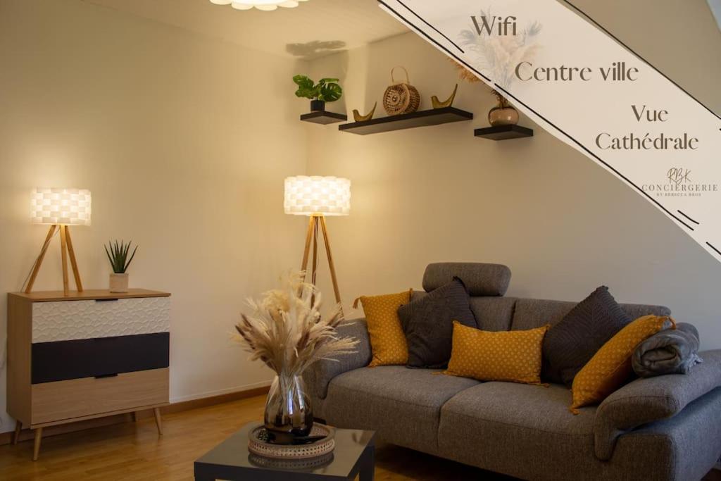 Mende Sweet Home - Vue Cathédrale - Wifi - Centre ville في مندي: غرفة معيشة مع أريكة وطاولة