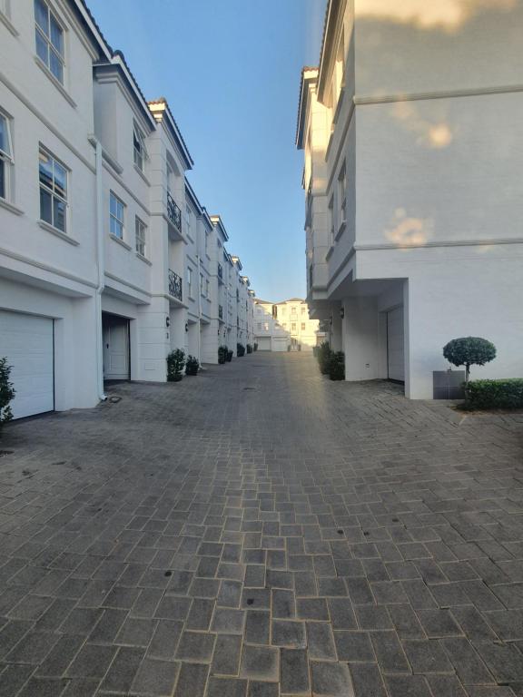 an empty alley between two white buildings at Royal Manor in Johannesburg