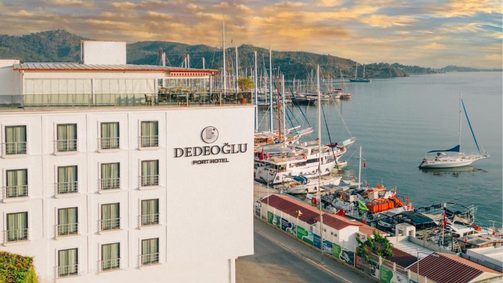 un edificio junto a un puerto deportivo con barcos en el agua en Dedeoğlu Port Hotel en Fethiye