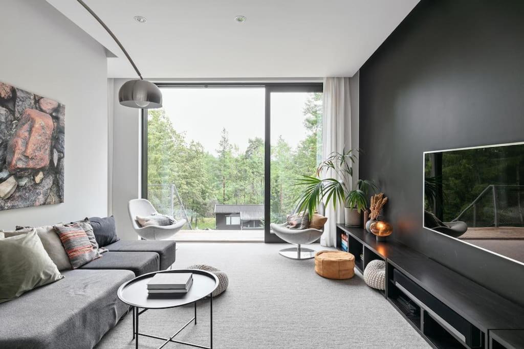 a living room with a couch and a tv at Swedish Elegance & Luxury Home in Stockholm