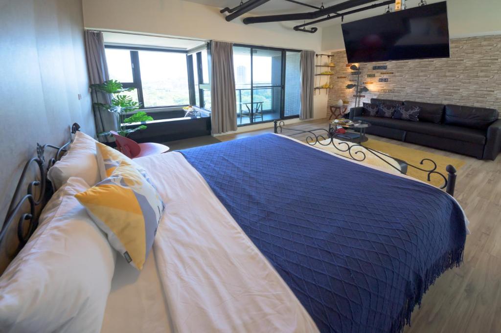 1 dormitorio con 1 cama grande y sala de estar en Yilan A Happy Apartment, en Hsin-hsing
