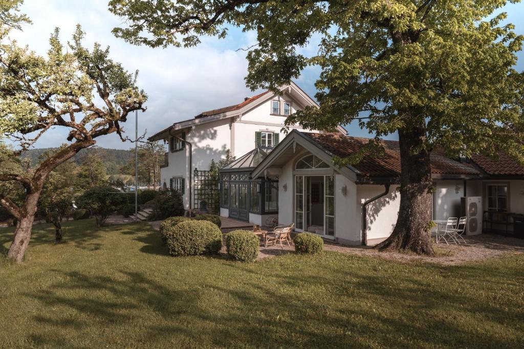 a white house with trees in the yard at Apartment Søglas in Gmund am Tegernsee