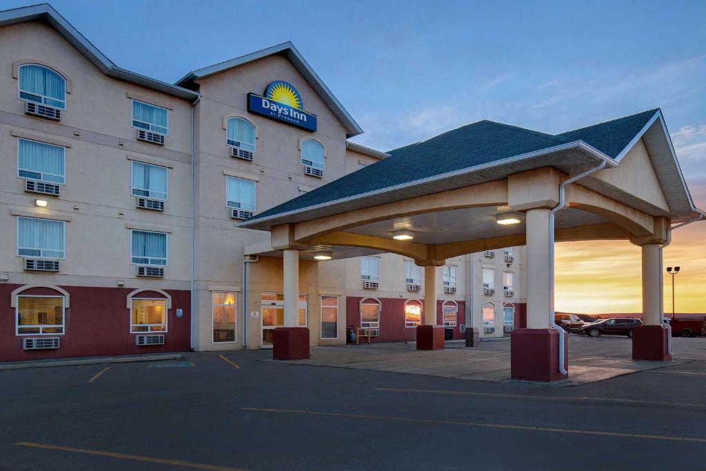 a hotel with a gazebo in a parking lot at Days Inn by Wyndham Dawson Creek in Dawson Creek