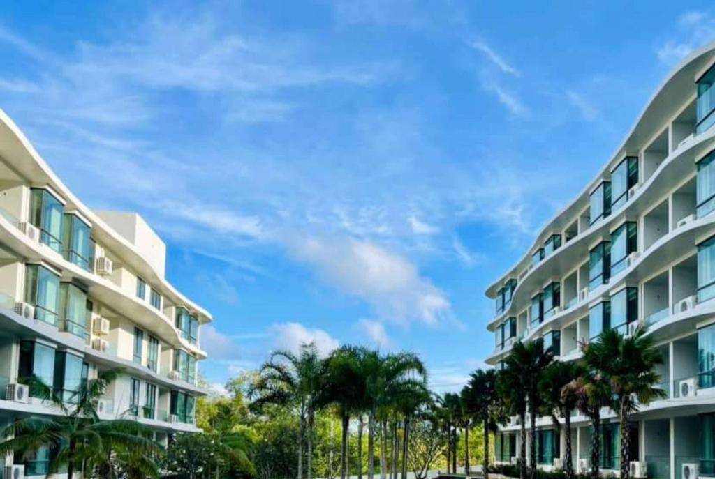 a row of apartment buildings with palm trees at Wyndham La Vita Rawai Phuket in Rawai Beach