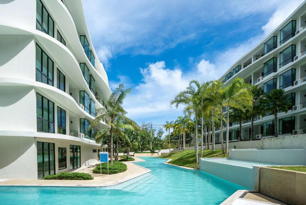 a swimming pool in front of a building at Wyndham La Vita Rawai Phuket in Rawai Beach