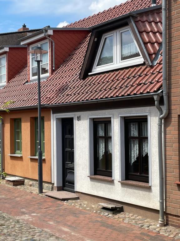 una casa con techo rojo y ventanas negras en Mecklenburg Vorpommern en Neukalen