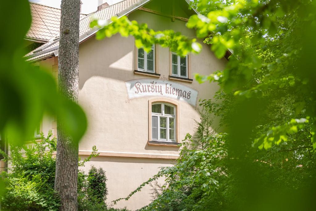 a building with a sign on the side of it at Villa Bachmann - Kuršių kiemas in Juodkrantė