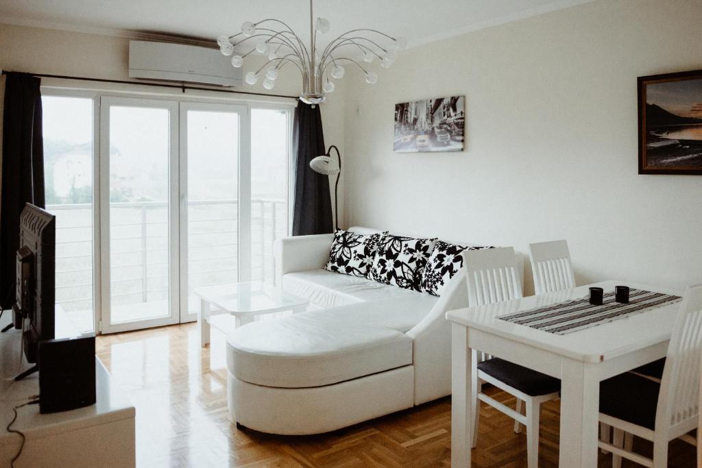 a living room with a white couch and a table at Apartman Hana in Gornja Toplica