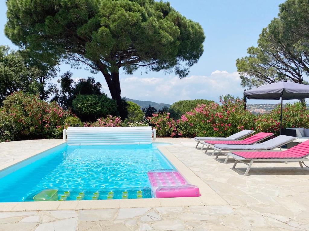 a swimming pool with lounge chairs and an umbrella at Villa avec piscine privée in Sainte-Maxime