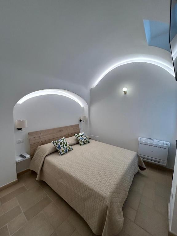 a bedroom with a bed with an arch above it at Nonna Cia in Gallipoli