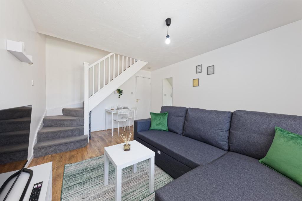 een woonkamer met een blauwe bank en groene kussens bij Comfortable Home in Kent, Sleeps 6 - Parking Available in Kent