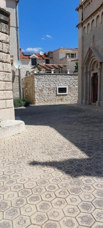 a cobblestone walkway in front of a building at Apartments villa Mira in Kaštela