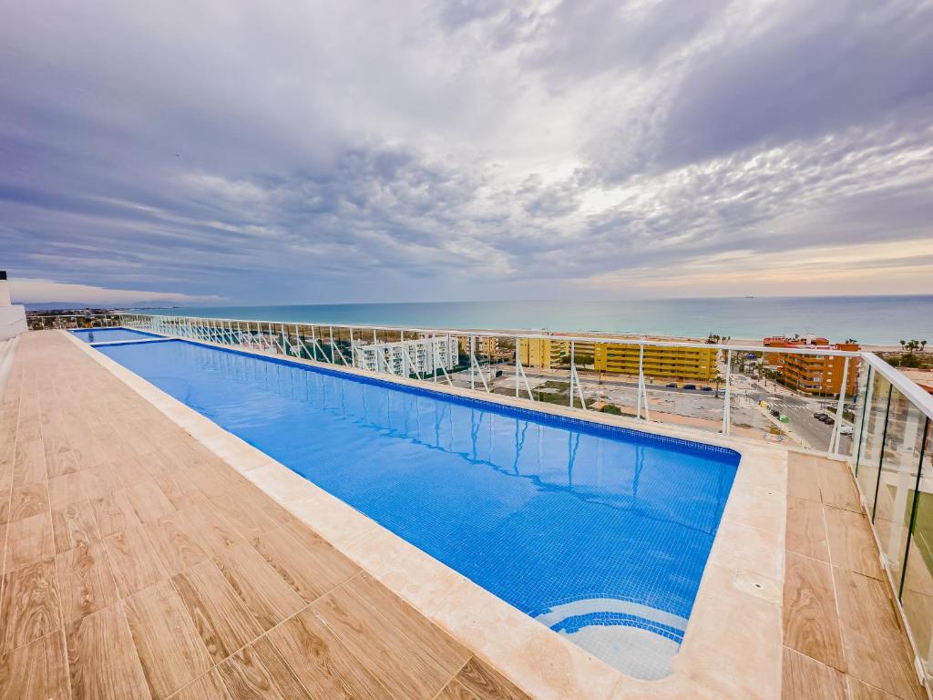 a swimming pool on the roof of a building with the ocean at Tranquilidad a 2 minutos del mar in Canet de Berenguer