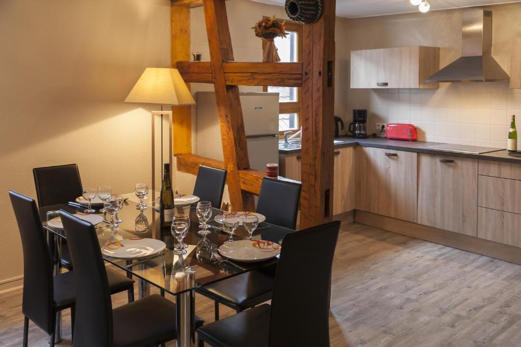 une salle à manger avec une table et des chaises ainsi qu'une cuisine dans l'établissement Gîte les Cigogneaux, à Turckheim