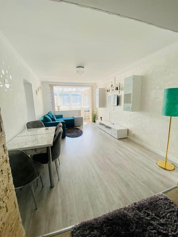 a living room with a blue couch and a table at Apartament Tiron în centru orasului in Gura Humorului