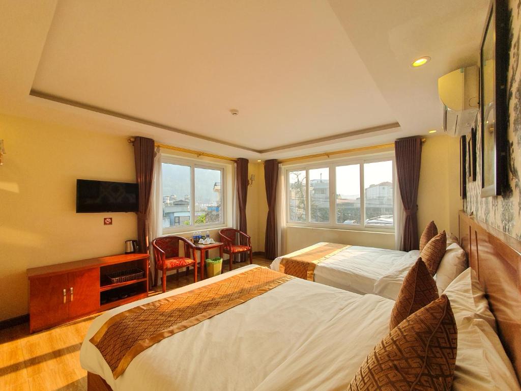 Habitación de hotel con 2 camas y ventana en Nghiêng Sapa Hotel en Sa Pa