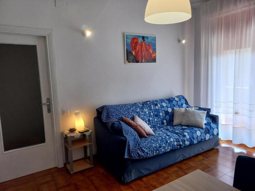 sala de estar con sofá azul y almohadas en Grazioso Bilocale Caletta Castiglioncello - Tuscany, en Castiglioncello