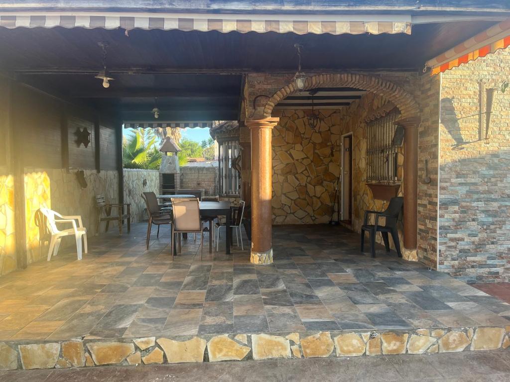 an outdoor patio with a table and chairs at Chalet , a 6km de la playa in Chiclana de la Frontera