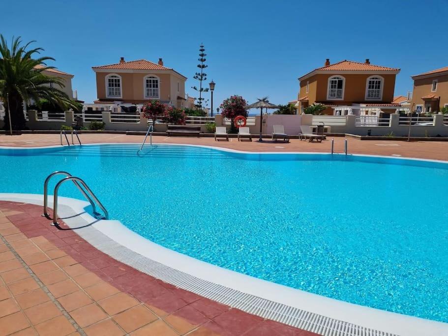 a large blue swimming pool in front of some houses at Villa Maracay-Caleta de Fuste-fiber optic 600mb in Caleta De Fuste