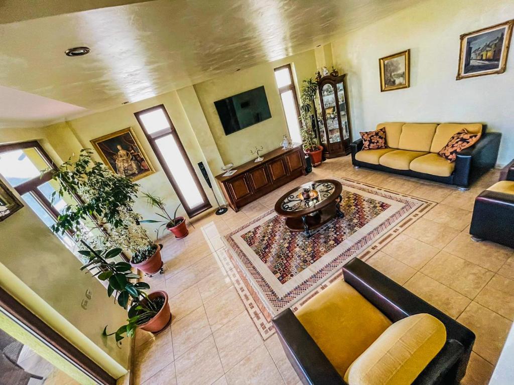 a large living room with couches and plants at Vila Orange in Mamaia Sat/Năvodari